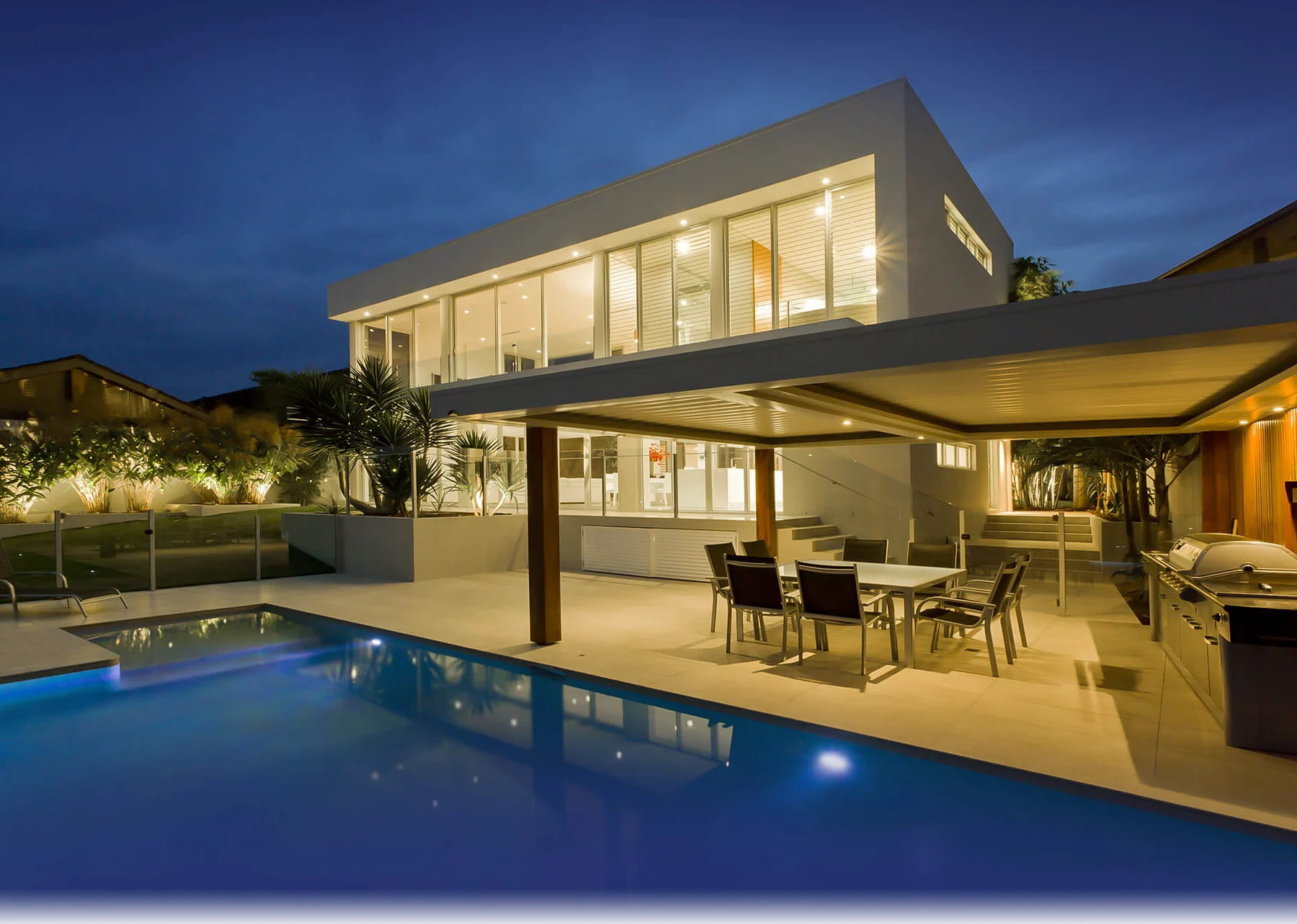 Residência de cliente com iluminação arquitetônica integrada ao lado de uma piscina
